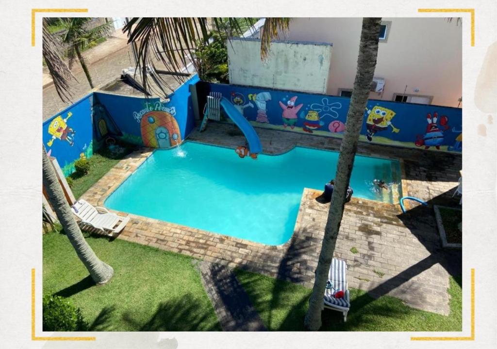 uma piscina vazia com escorrega num parque infantil em Hostel Recanto Peruíbe em Peruíbe