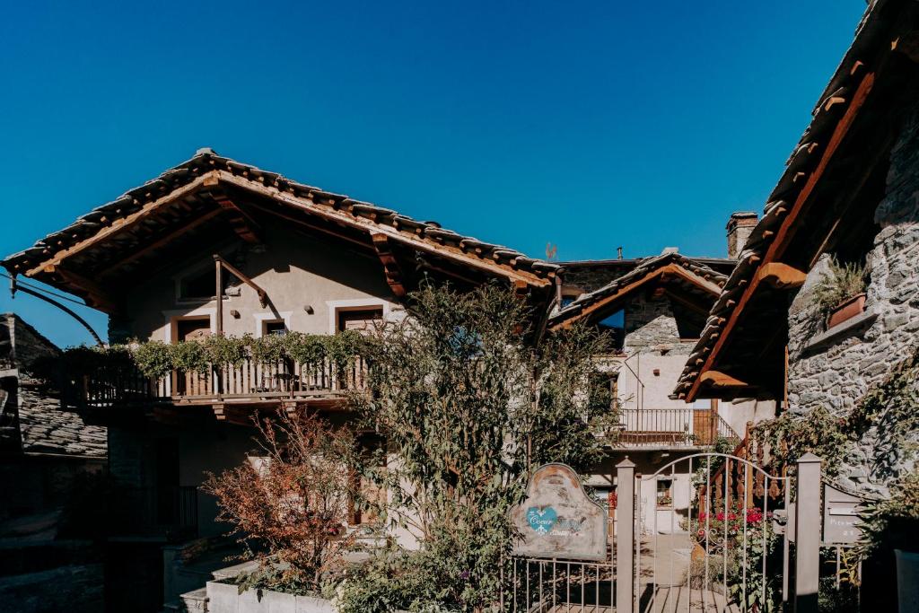 ein Haus mit einem Balkon an der Seite in der Unterkunft Au coeur du village Chambes d'hôtes & SPA in Arnad