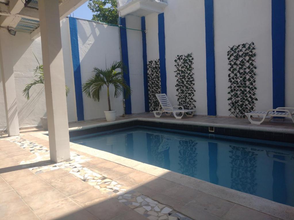 una piscina con 2 sillas y un edificio en Blue Diamond House, en Cartagena de Indias