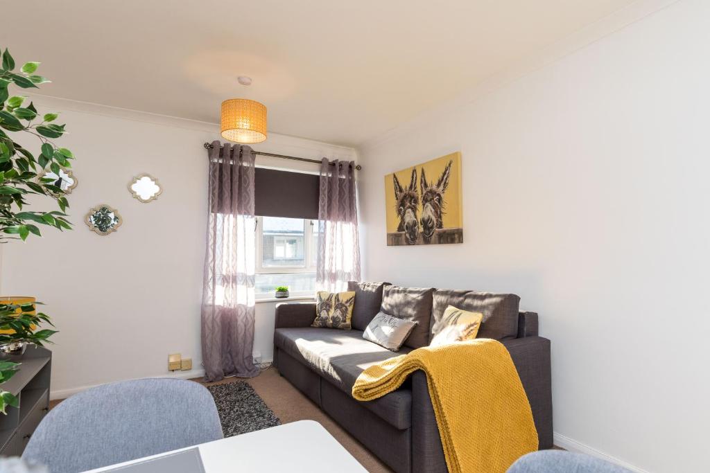 ein Wohnzimmer mit einem Sofa und einem Fenster in der Unterkunft 19A The Broadwalk Apartment- 1BR in Crawley