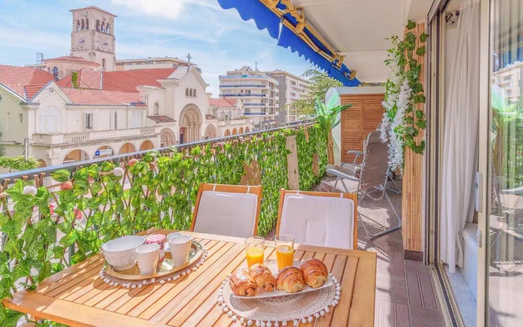 une table avec de la nourriture et des boissons sur un balcon dans l'établissement Le Concorde - Charmant appt avec terrasse, à Cannes