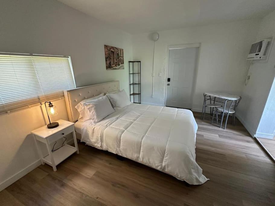 a bedroom with a large white bed and a table at Stylish Studio Brickell/Little Havana@ItalianPlaza in Miami
