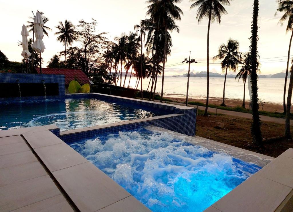 ヤオノイ島にあるAn Pao Beach Residence Villa 1 - Koh Yao Noiの青い水とヤシの木が茂るスイミングプール