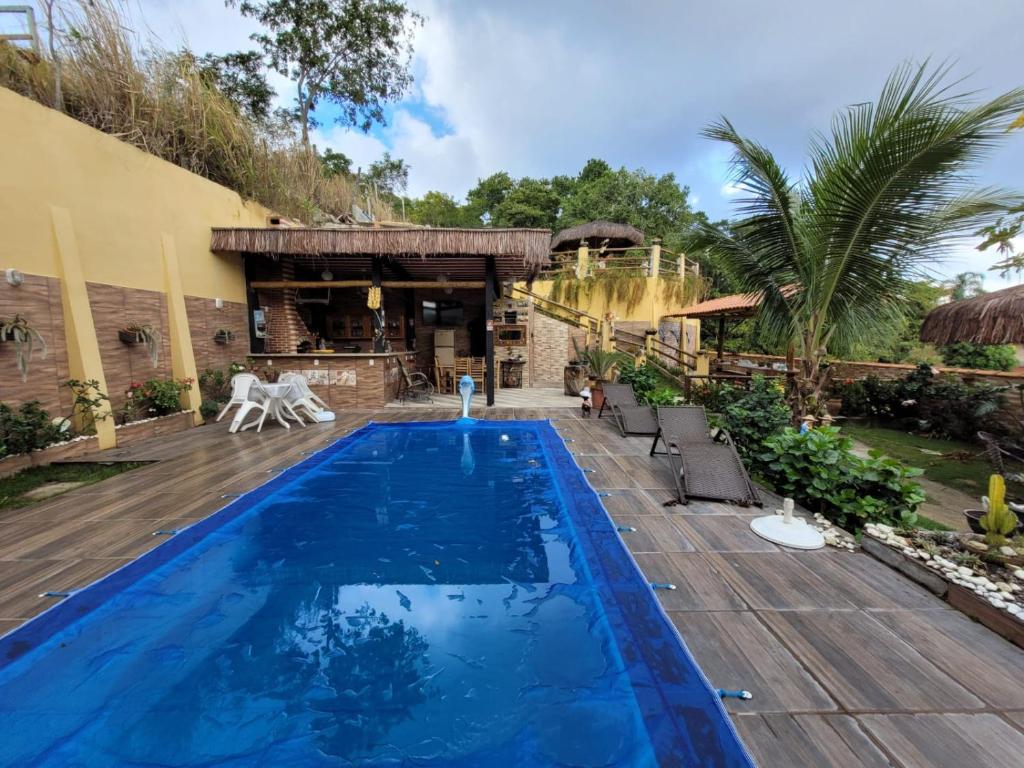 uma piscina num quintal com um deque de madeira em Pousada Mirante Pôr do Sol em Maricá