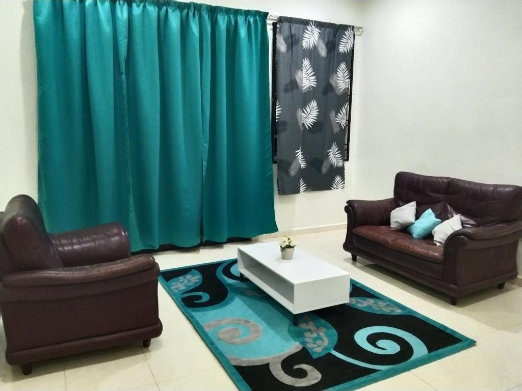a living room with two chairs and a coffee table at Ammar Homestay Tok Bali in Kampong Ayer Tawar