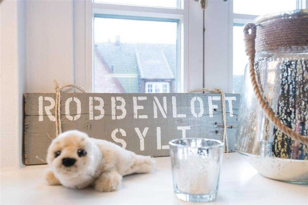 een teddybeer die op een tafel naast een bord zit bij Robbenloft-Wohnung-11 in Keitum