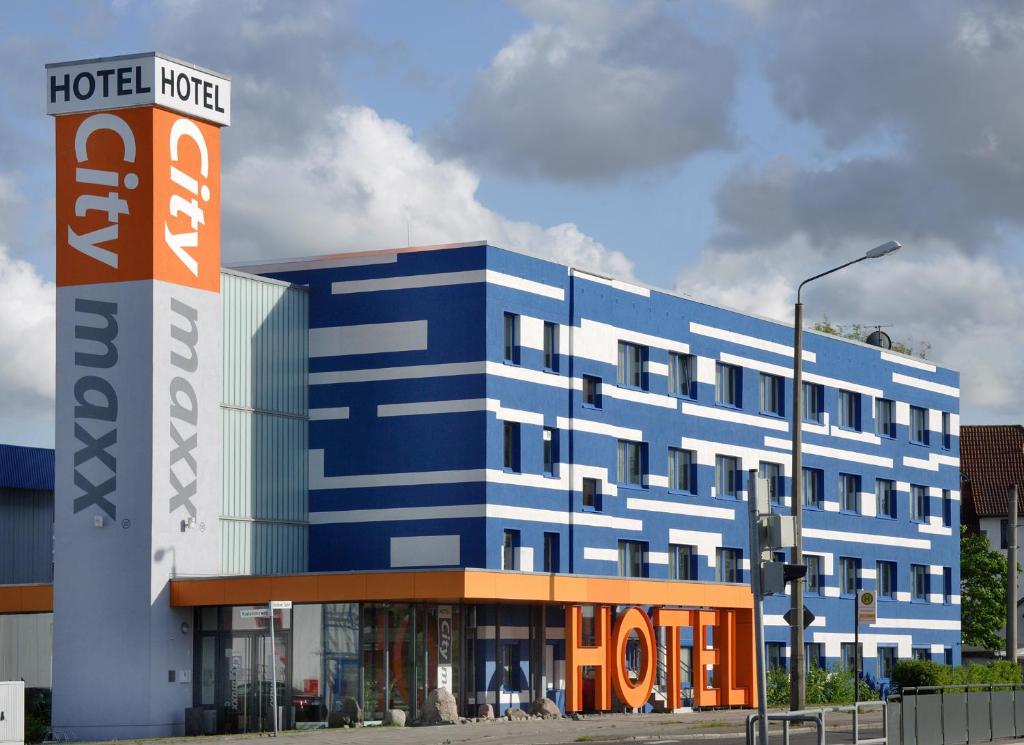 a large blue building with a sign in front of it at Hotel Citymaxx in Rostock