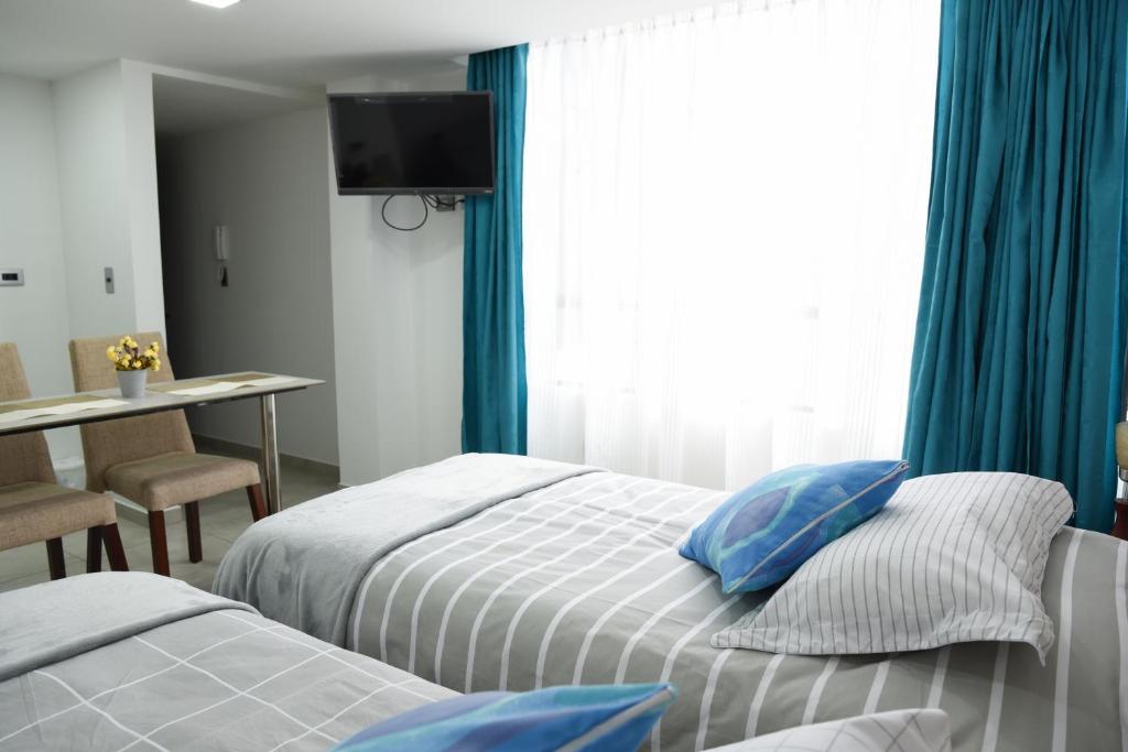 1 dormitorio con 2 camas, mesa y ventana en Apartaestudios, La Castilla Avenida de los Estudiantes, en Pasto