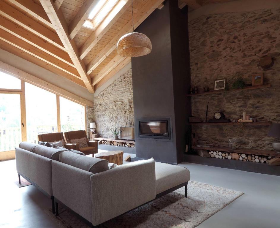 sala de estar con sofá y chimenea en Espectacular Chalet de Montaña Pirineos, Burg, en Burg