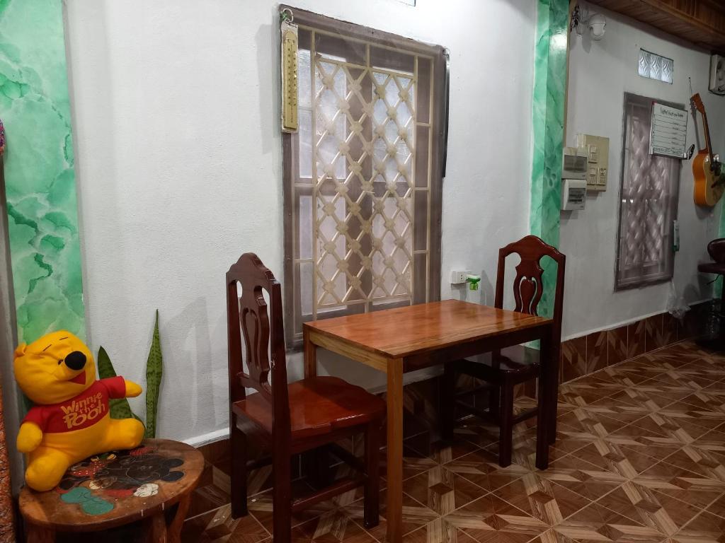 a dining room with a table and chairs and a stuffed animal at watthat & Maladress GUESTHOUSE in Luang Prabang