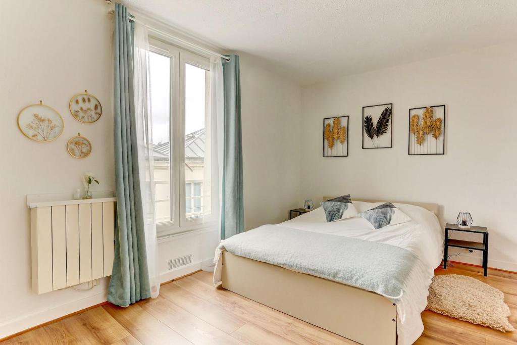 sypialnia z łóżkiem i dużym oknem w obiekcie Le Dangeau - Versailles w Wersalu