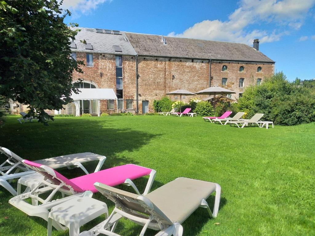 - un groupe de chaises longues et de chaises devant un bâtiment dans l'établissement Maison Berton, à Gedinne