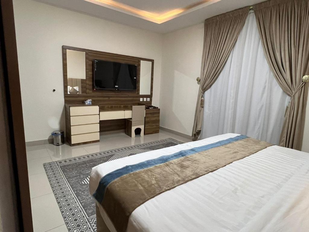a bedroom with a bed and a large mirror at اجنحة بيادر السكنية in Al Madinah