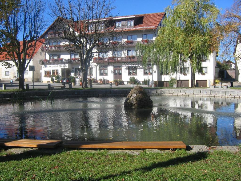 um grande edifício em frente a um lago com um edifício em Hotel Gasthof Rössle em Stetten am Kalten Markt
