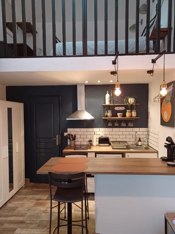 une cuisine avec une table et quelques chaises dans l'établissement Studio privé avec terrasse entrée indépendante, à Saint-Nazaire