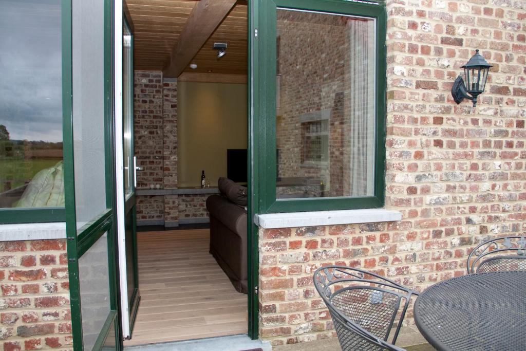 an open patio door with a table and chairs at B&amp;B - Ter Douve in Dranouter