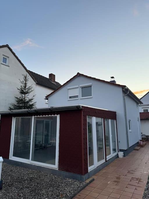 a white and red house with glass doors at Kuscheliges Einfamilienhaus in Lingenfeld