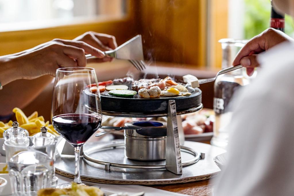 a person sitting at a table with a plate of food at Hauser Hotel St. Moritz in St. Moritz