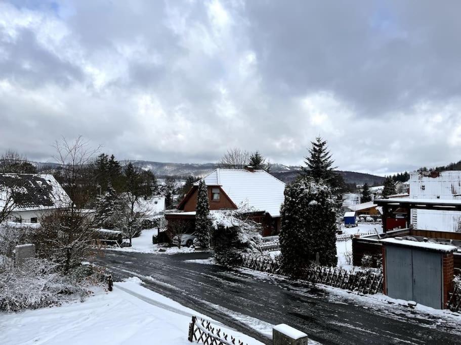 ein schneebedecktes Dorf mit einer Straße und Gebäuden in der Unterkunft Ferienhaus Marianne im Harz in Langelsheim