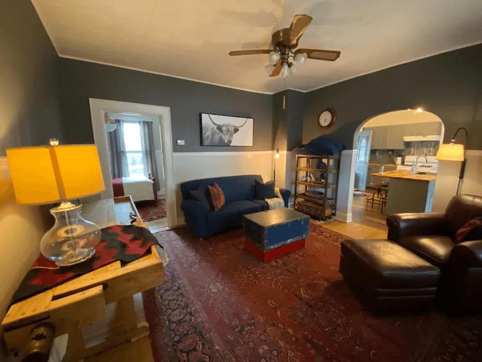 un soggiorno con divano blu e ventilatore a soffitto di Cozy 3 & 4 Bed Home 2 Blocks to Hospitals & Lambeau a Green Bay