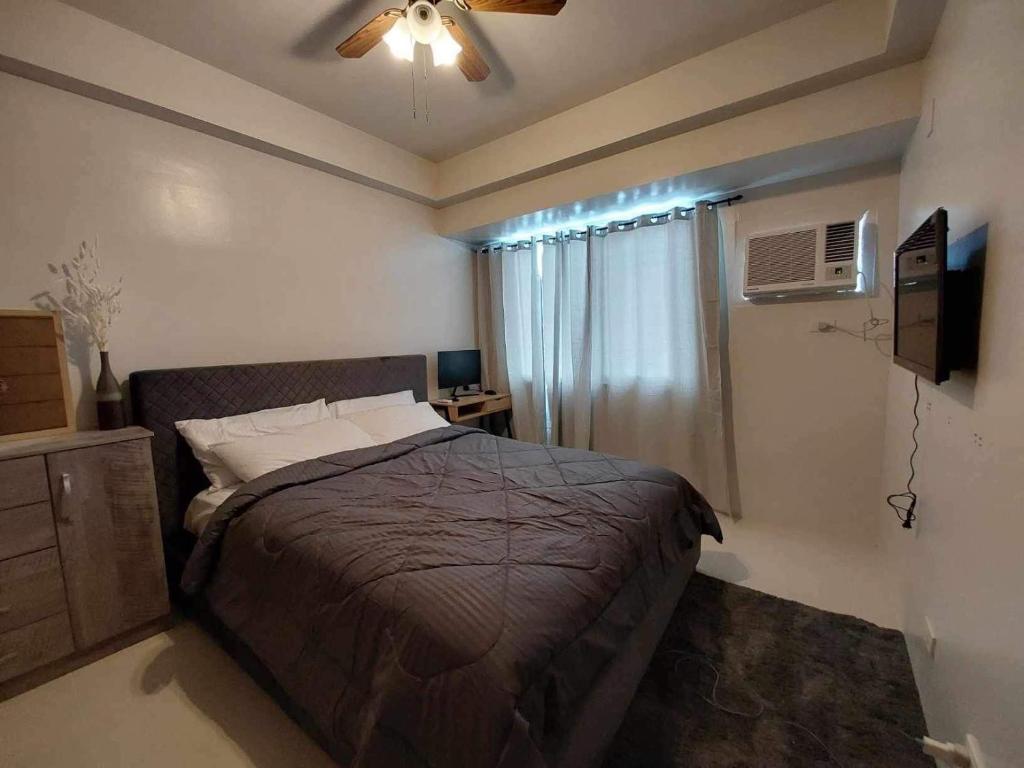 a bedroom with a bed and a ceiling fan at Cebu 1 bed Luxury Condo with high speed Internet in Cebu City