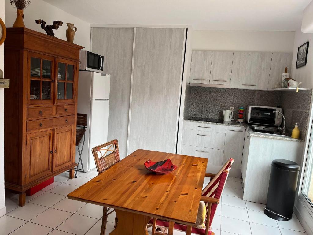 a kitchen with a wooden table with chairs and a refrigerator at 4SAP22 Appartement climatisé avec double terrasses in Collioure
