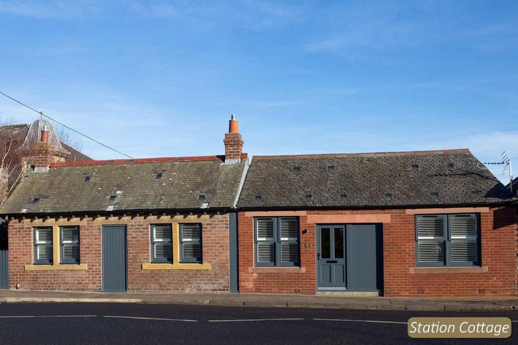 a brick house on a street with the golden gate bridge at Station Cottage in North Berwick