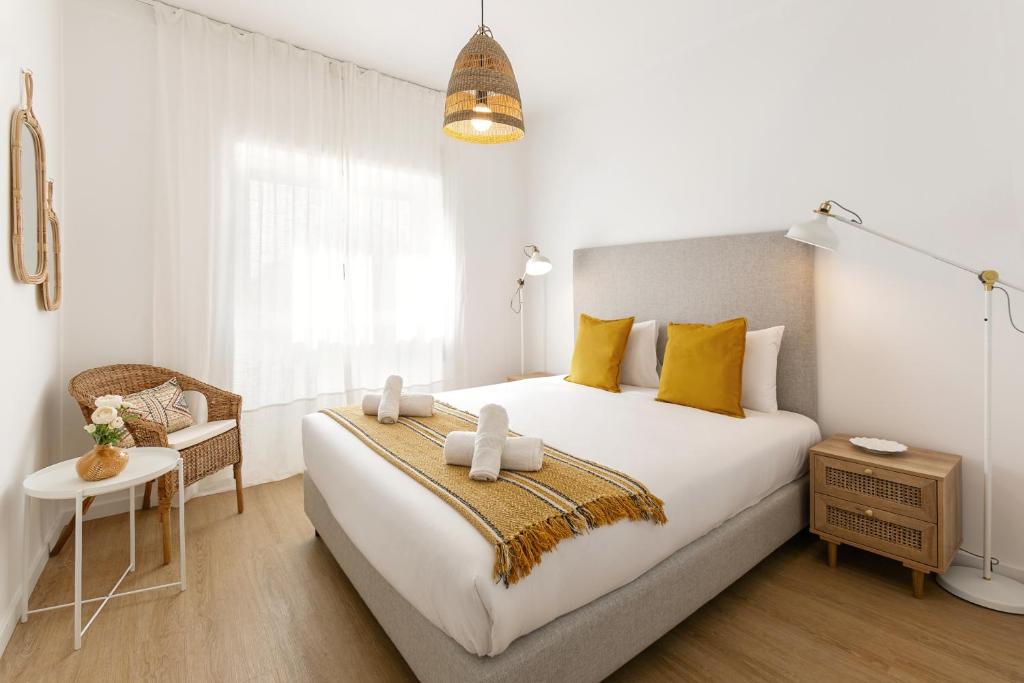 Un dormitorio con una gran cama blanca con almohadas amarillas. en Estrelas da Praia, en Consolacao