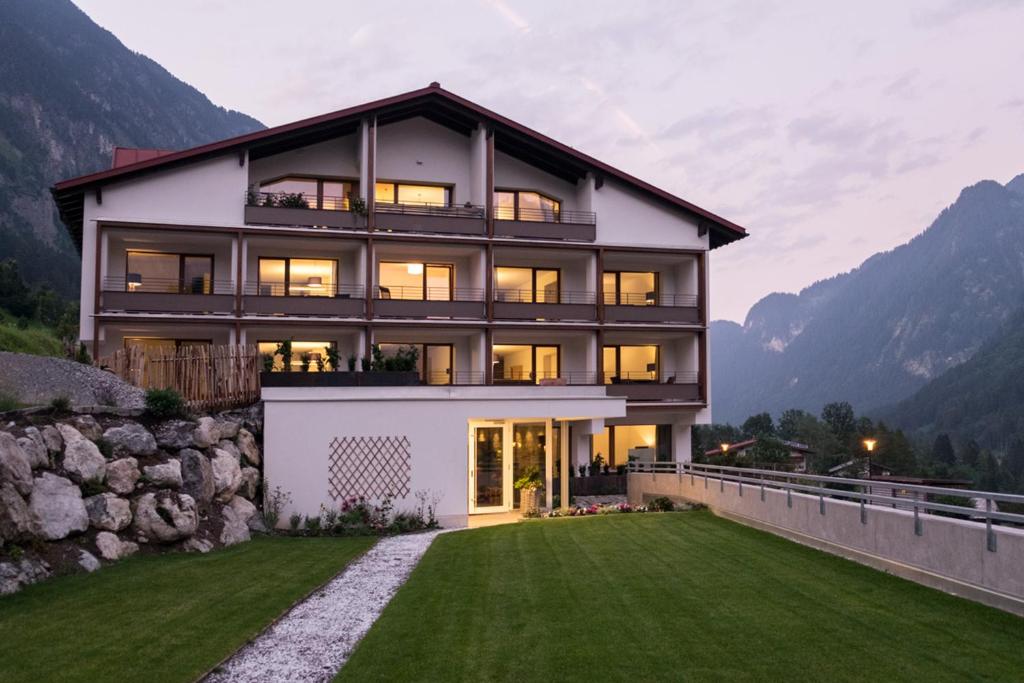 a house in the mountains with a green lawn at Valschena Appartements in Brand