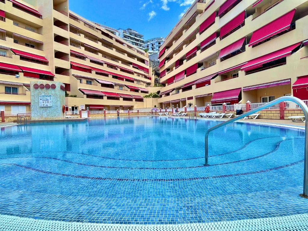 a large swimming pool in the middle of a building at Kpaco Apartment in Puerto de Santiago