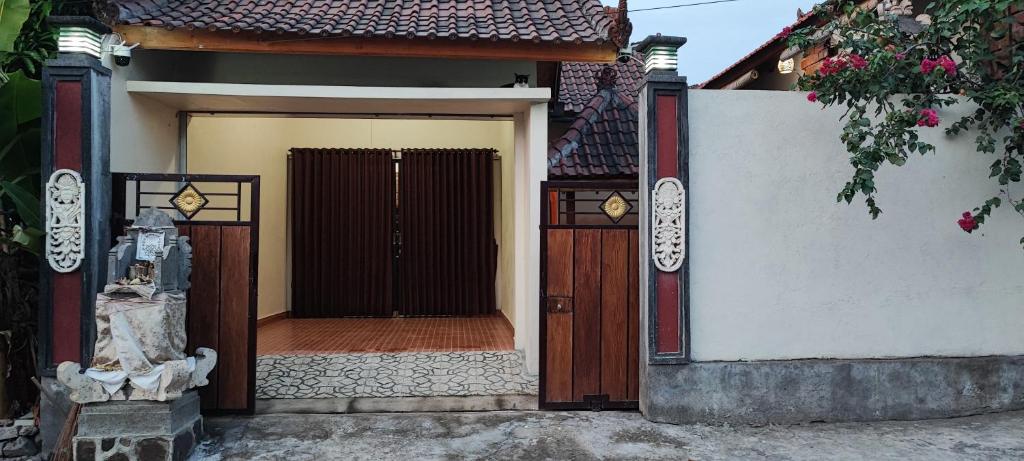 een toegang tot een huis met een poort en een deur bij Lala Guest House in Bubunan