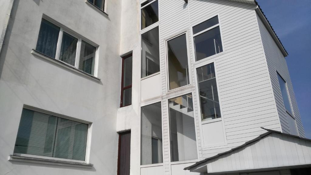 un edificio blanco con ventanas laterales en Jurgis Guest house en Kaunas