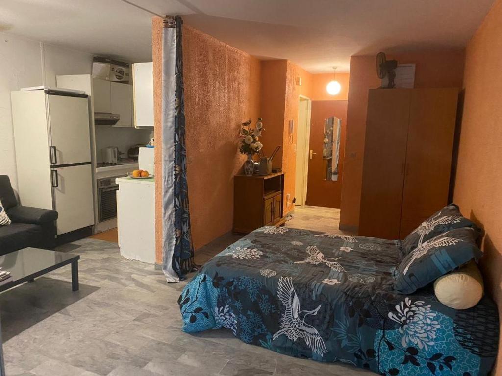 1 dormitorio con 1 cama y cocina con nevera en APPARTEMENT MAS DSU TANIT en Antibes