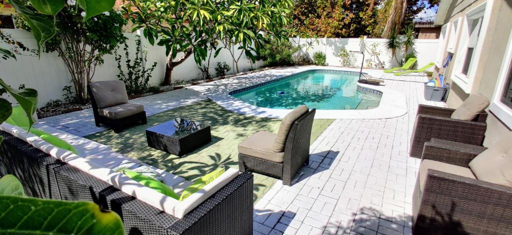 a small swimming pool with chairs and a table at The Villa Verde - Luxury Clearwater by BlueBellaEstate in Largo