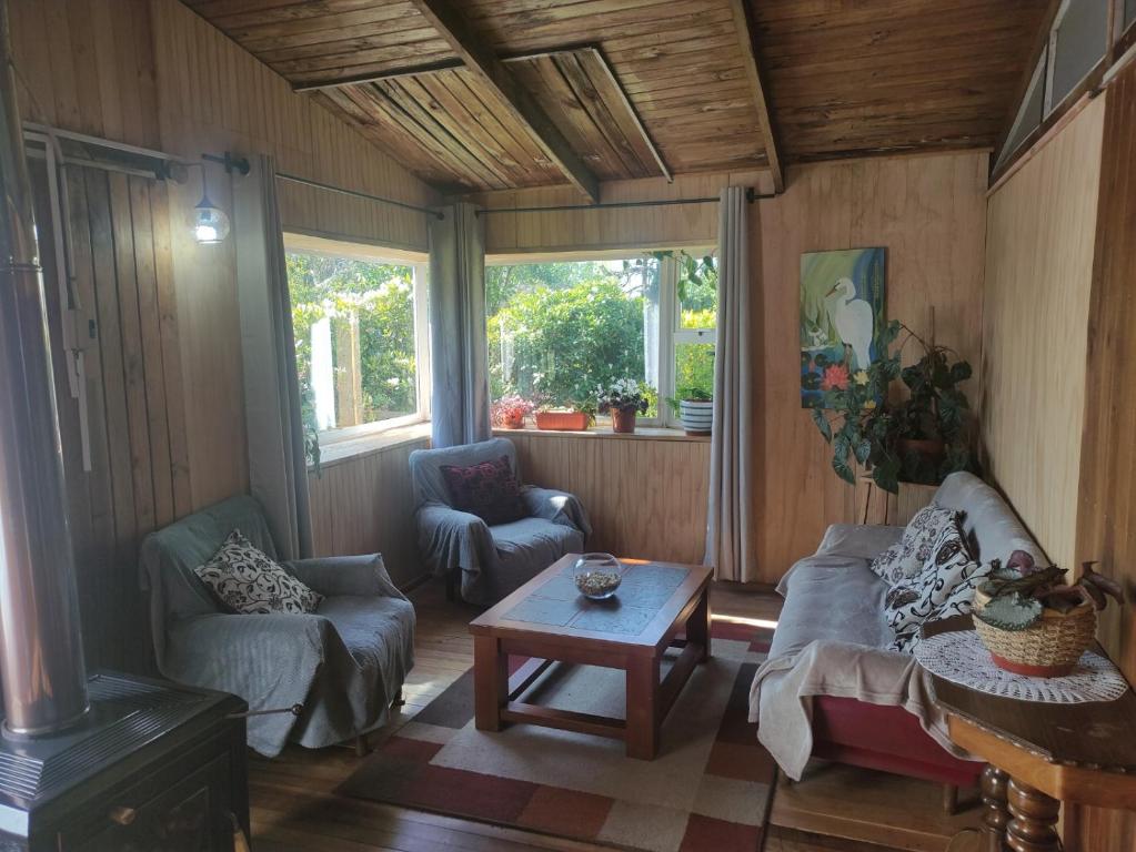 ein Wohnzimmer mit 2 Stühlen und einem Tisch in der Unterkunft Cabana El Sauce in San Patricio