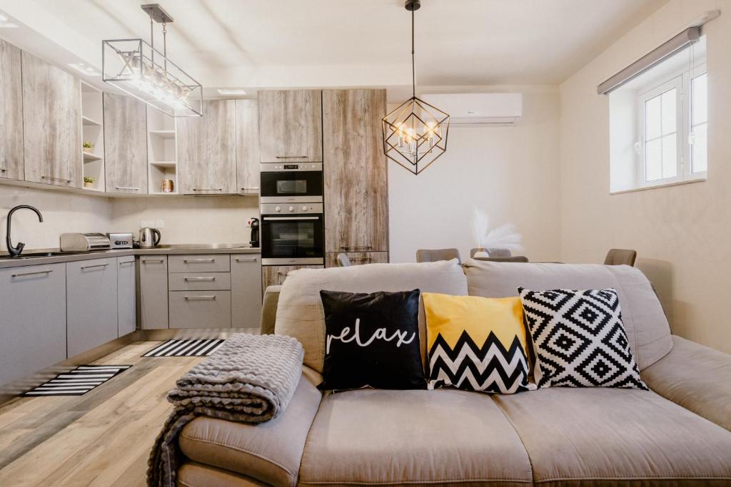 uma sala de estar com um sofá e uma cozinha em LA88 Bayview Rooms em Sliema