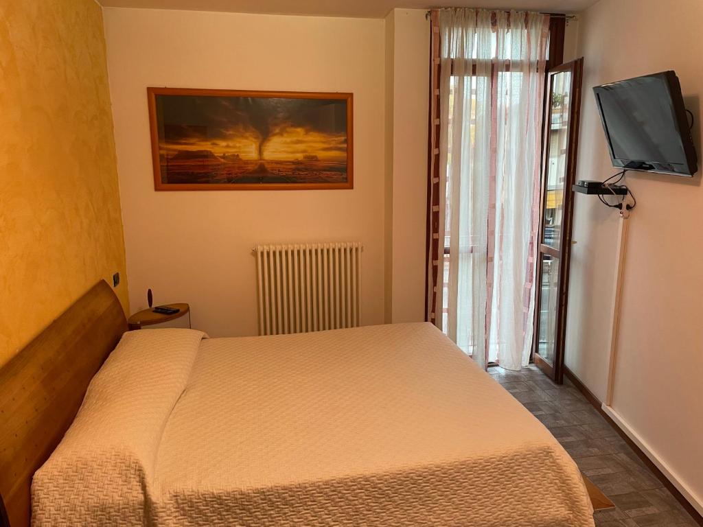 a bedroom with a bed and a flat screen tv at Intero appartamento - Parma zona Fiera in Roncopascolo