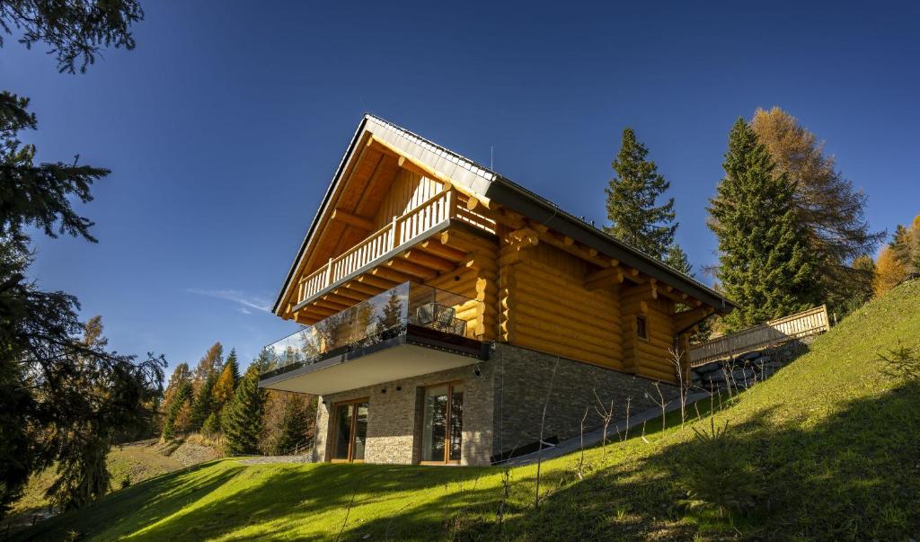 a house on top of a grassy hill at Chalet NON-SENS by L'Occitane in Hochrindl