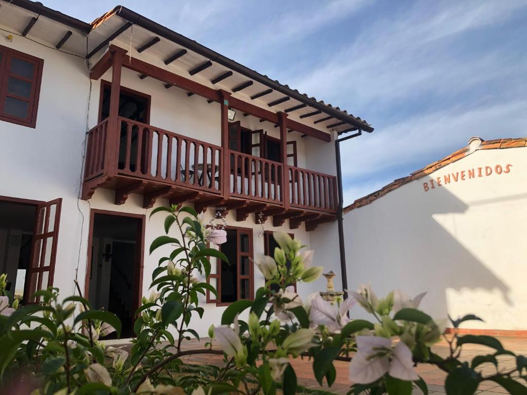 巴里查拉的住宿－Rustico Hostel Barichara，带阳台和鲜花的白色建筑