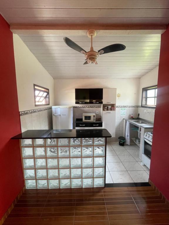a kitchen with a ceiling fan and a counter top at Flat Maricá com ar-condicionado in Maricá