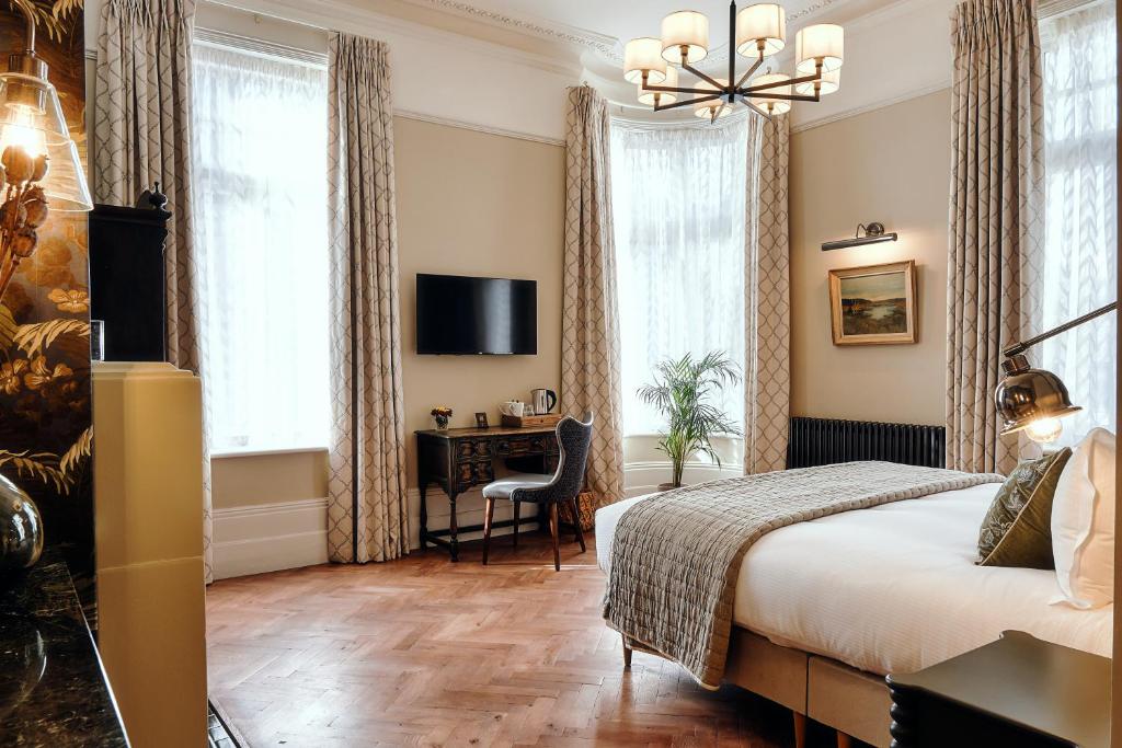 Schlafzimmer mit einem Bett, einem Schreibtisch und einem TV in der Unterkunft The Black Lion Pub & Boutique Guesthouse in London