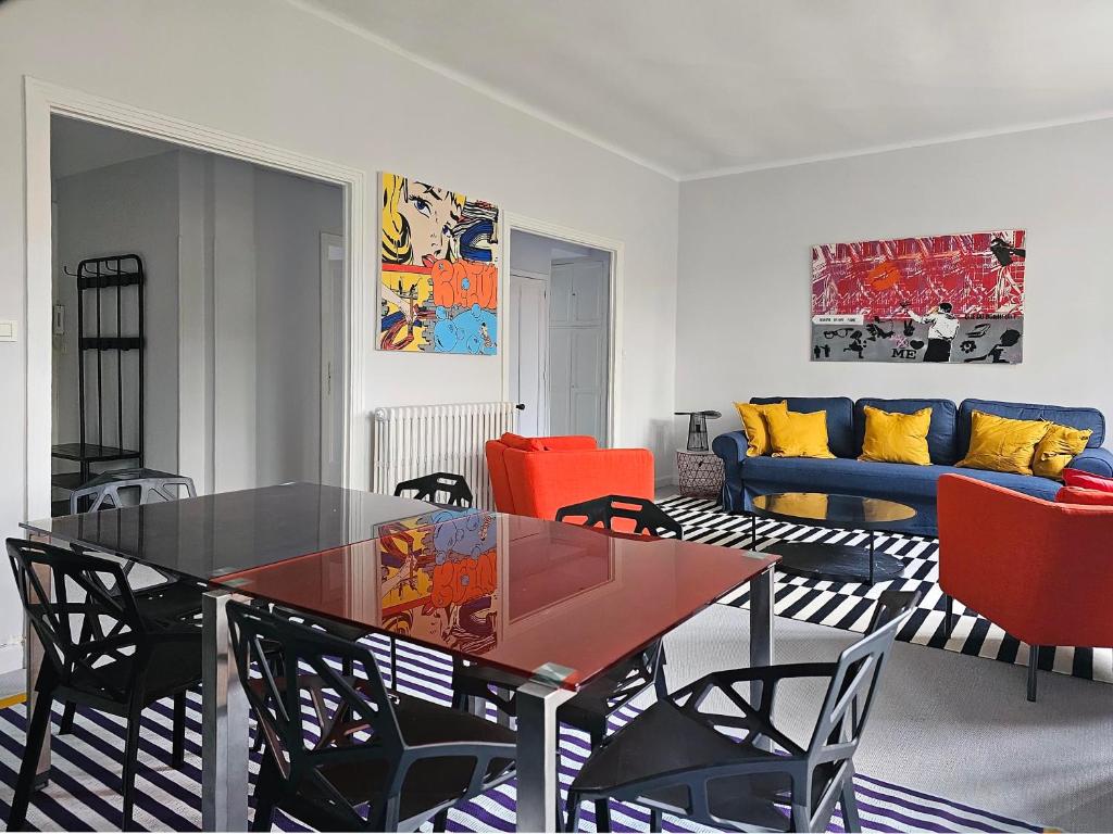 uma sala de estar com uma mesa de vidro e cadeiras em L'Idrac, Appartements en Hyper centre em Toulouse