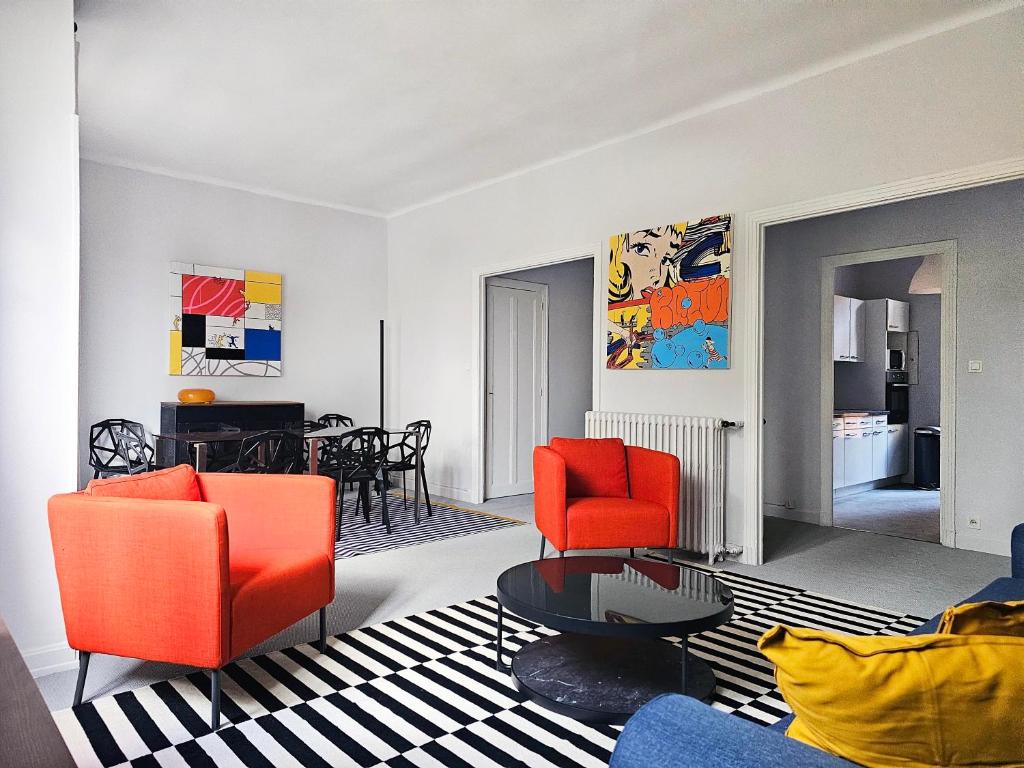 a living room with two orange chairs and a table at L&#39;Idrac, Appartements en Hyper centre in Toulouse