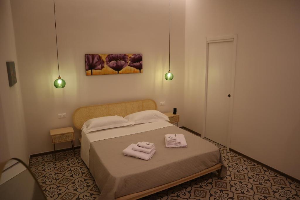 una camera da letto con un letto con due asciugamani sopra di Il Pumo a Locorotondo
