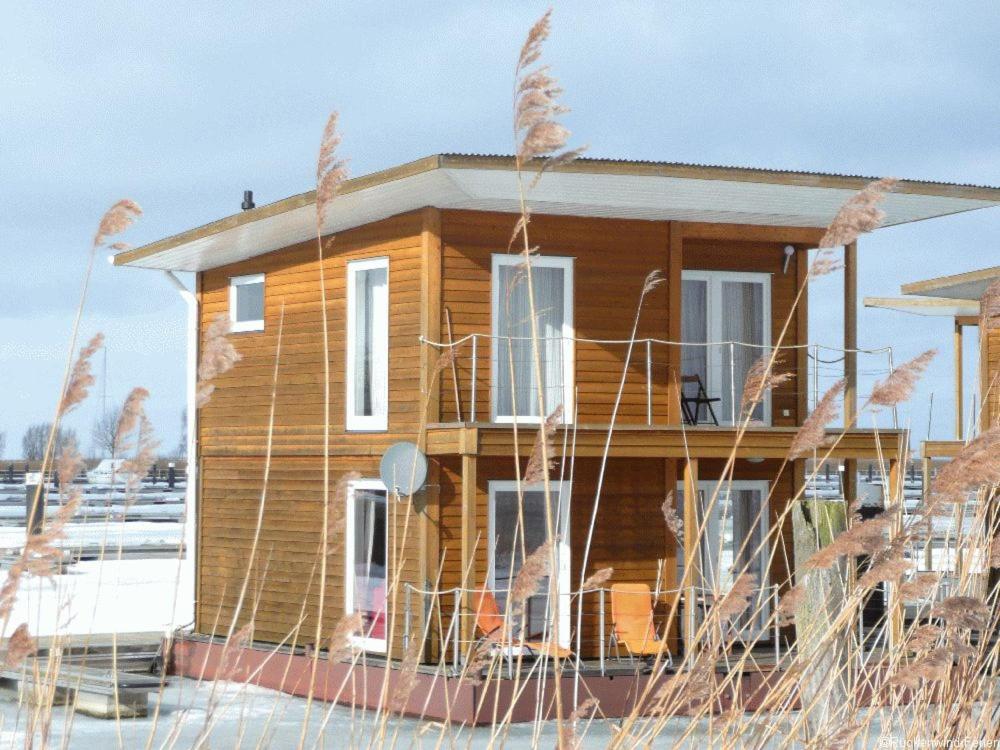 een huis in de sneeuw met hoog gras bij FLOATING HOUSES Comfort - "Schwimmende Ferienhäuser" - Haus 7 in Kröslin