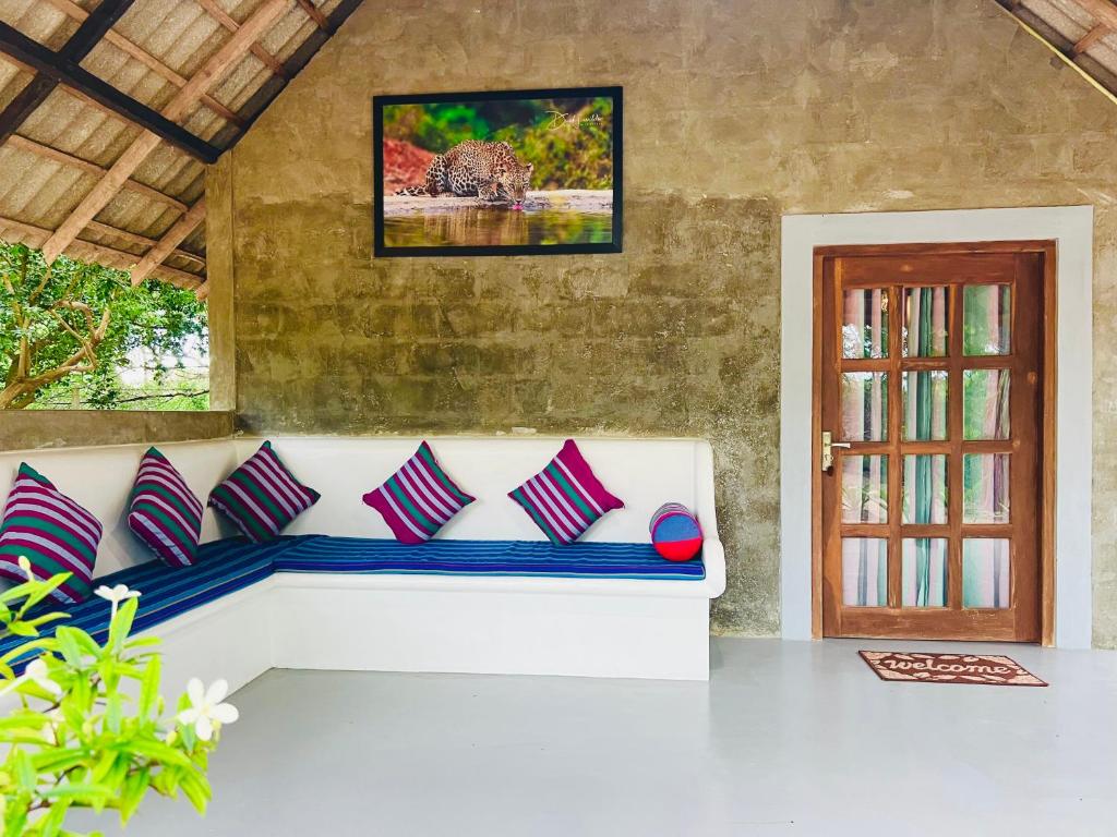 a white couch with pillows sitting in a room at Kingfisher Beach Resort-Yala in Kirinda