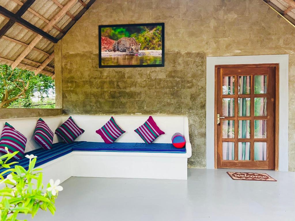 eine weiße Couch mit Kissen in einem Zimmer in der Unterkunft Kingfisher Beach Resort -Yala in Kirinda