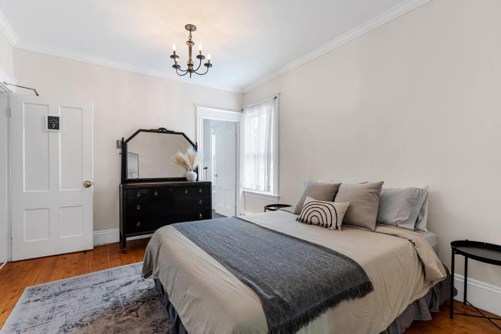 biała sypialnia z łóżkiem i lustrem w obiekcie Studio 7 ~ 1 BDRM w/ Private Bath & Living Room w mieście Moncton