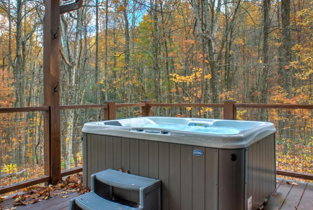 een hot tub op een terras in het bos bij Baby Bear: Peaceful cabin on Bearwallow Mountain with hot tub and close to hiking! in Hendersonville