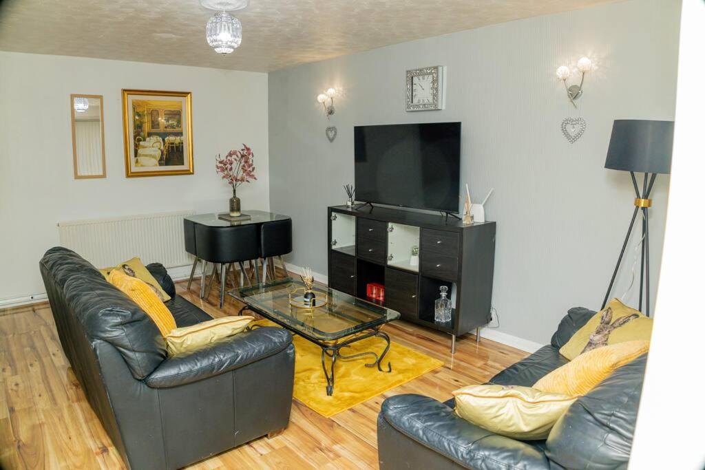 uma sala de estar com dois sofás e uma televisão em Charming 2-Bedroom in MANCHESTER em Manchester